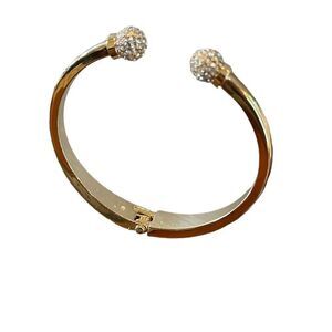 Gold tone bangle bracelet with two round crystal ends